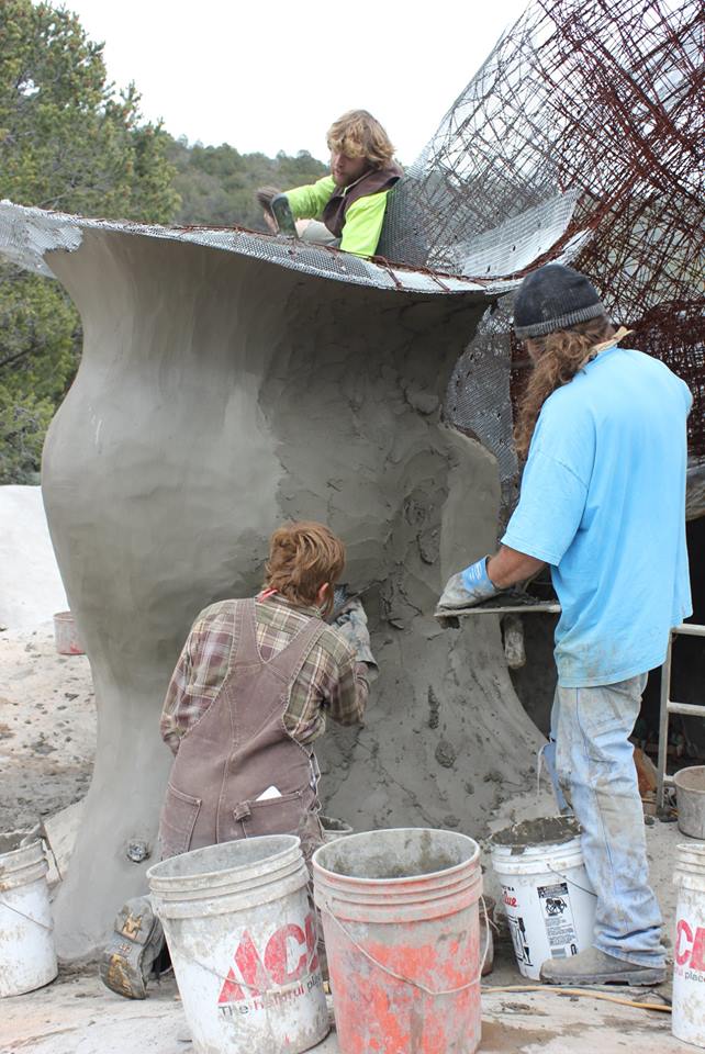 Men applying layers of plaster to a sculpted rain water cistern